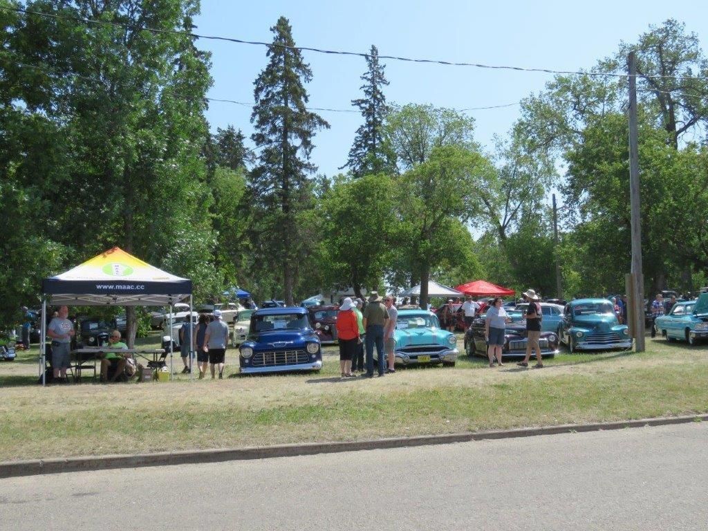 A group of people are standing in front of a car show