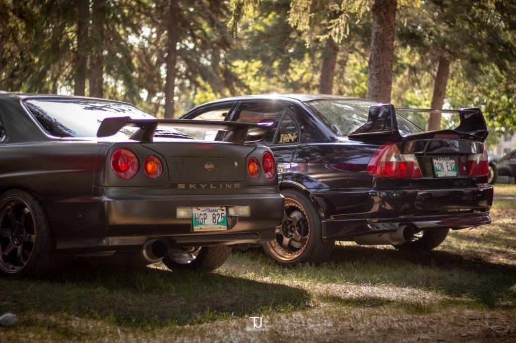 Two sports cars are parked next to each other in a park.