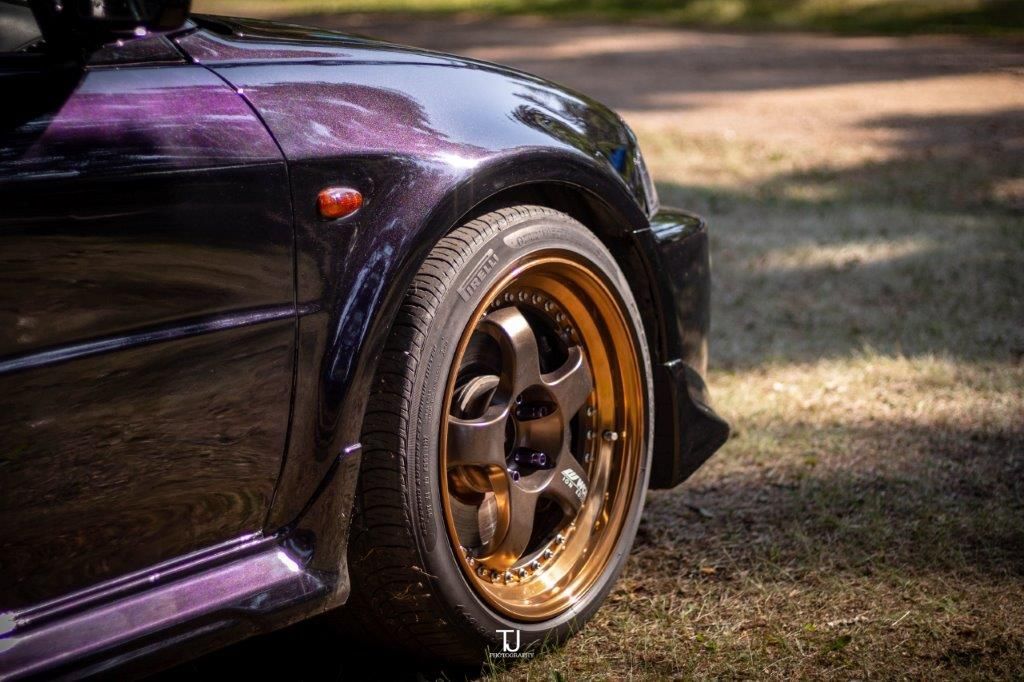 A close up of a car 's wheel on a grassy field.