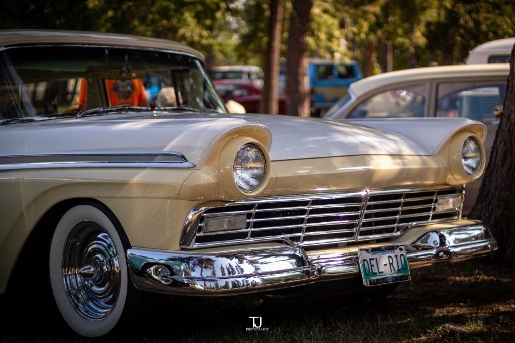 Two old cars are parked next to each other in a park.