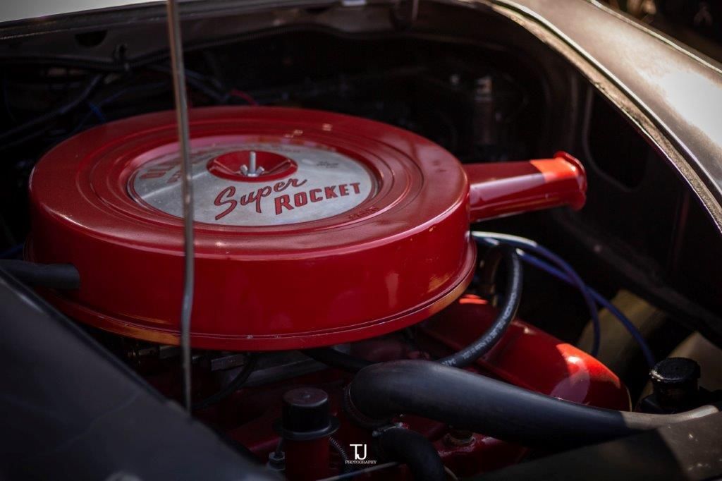 A close up of a red engine in a car.
