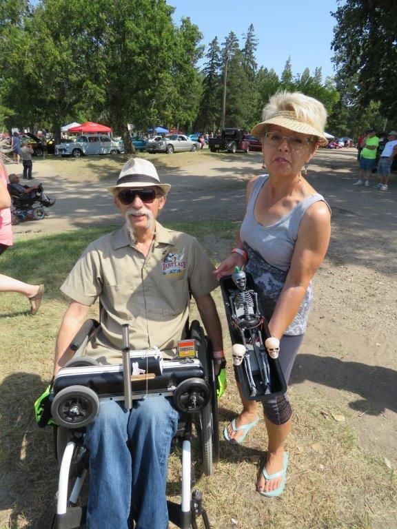 A man in a wheelchair is standing next to a woman.