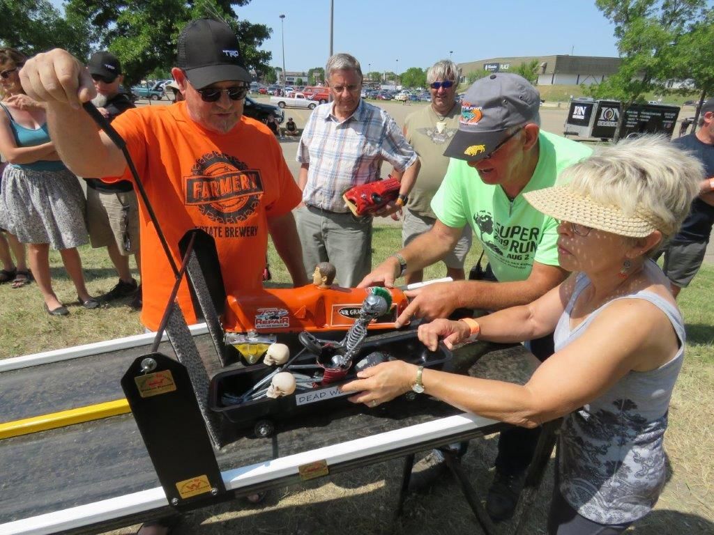 A group of people are standing around a table looking at a machine.