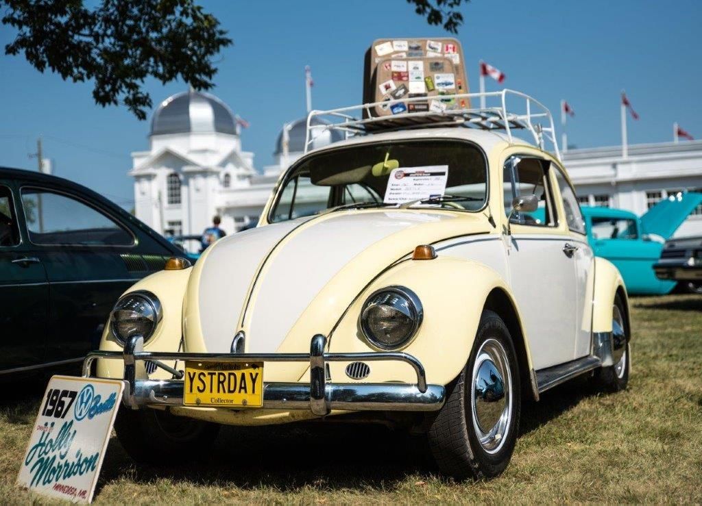 A yellow and white beetle with a new york license plate