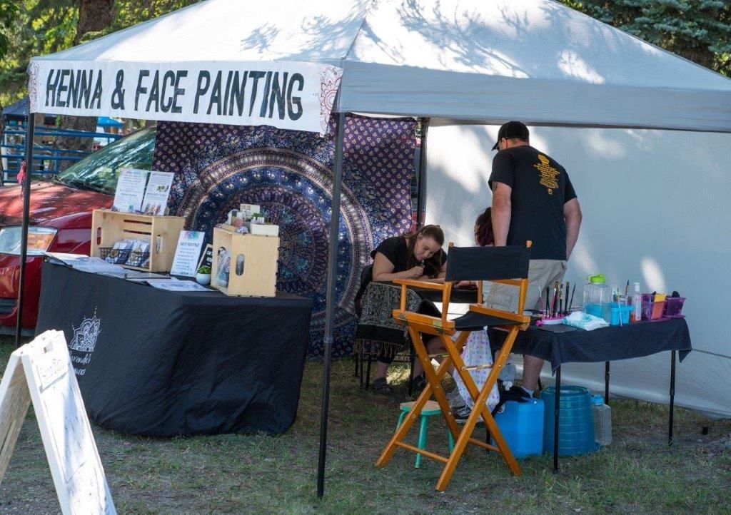 A tent with a sign that says henna and face paintings