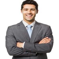 Man in gray pinstripe suit, arms crossed, smiling. Blue tie. White background.