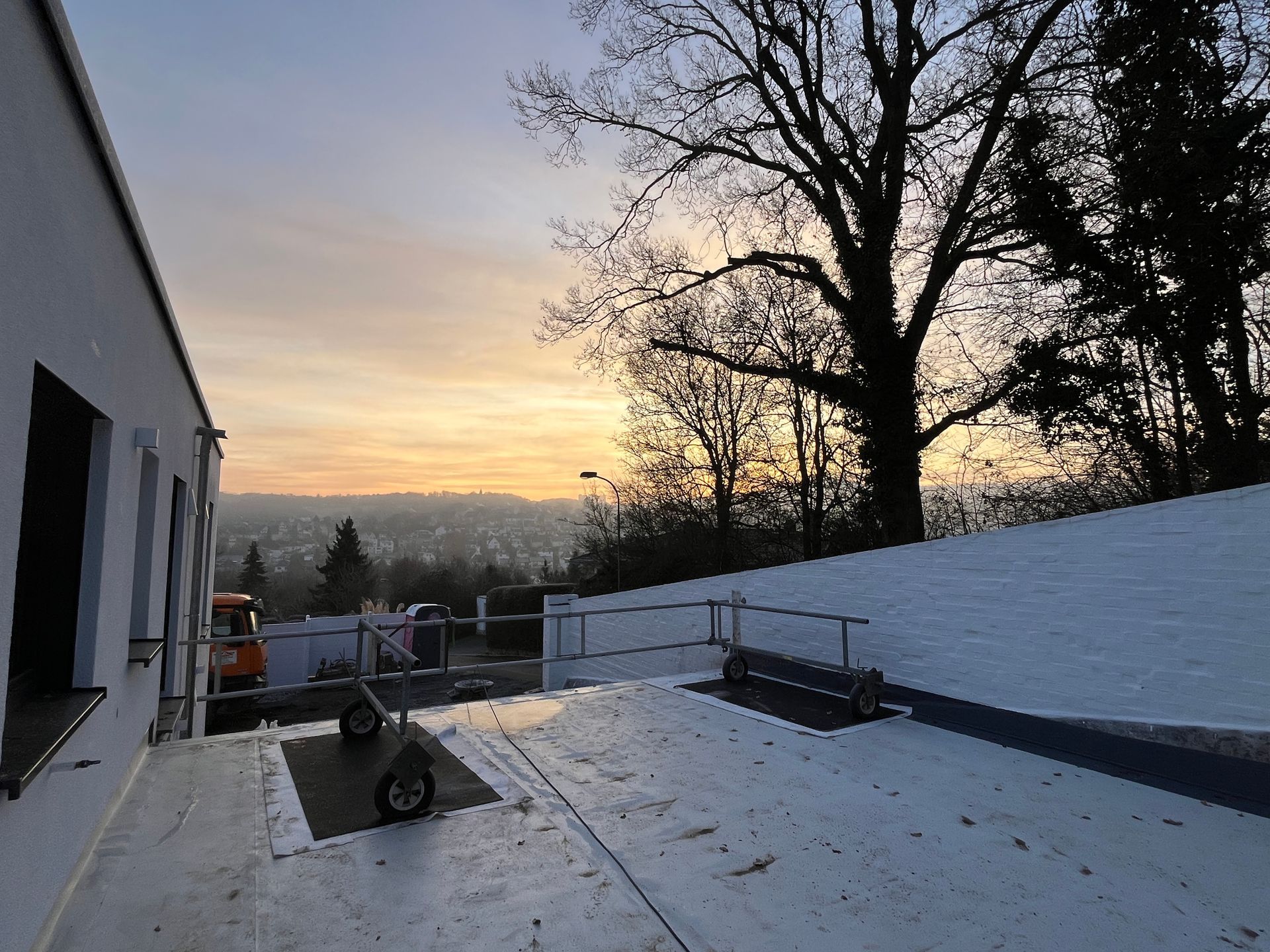 Ein schneebedeckter Balkon bietet Blick auf eine Landschaft im Sonnenuntergang; 