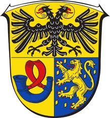 Wappen mit einem schwarzen Doppeladler auf Gold, einem blauen Jagdhorn auf Gold und einem goldenen Löwen auf Blau.