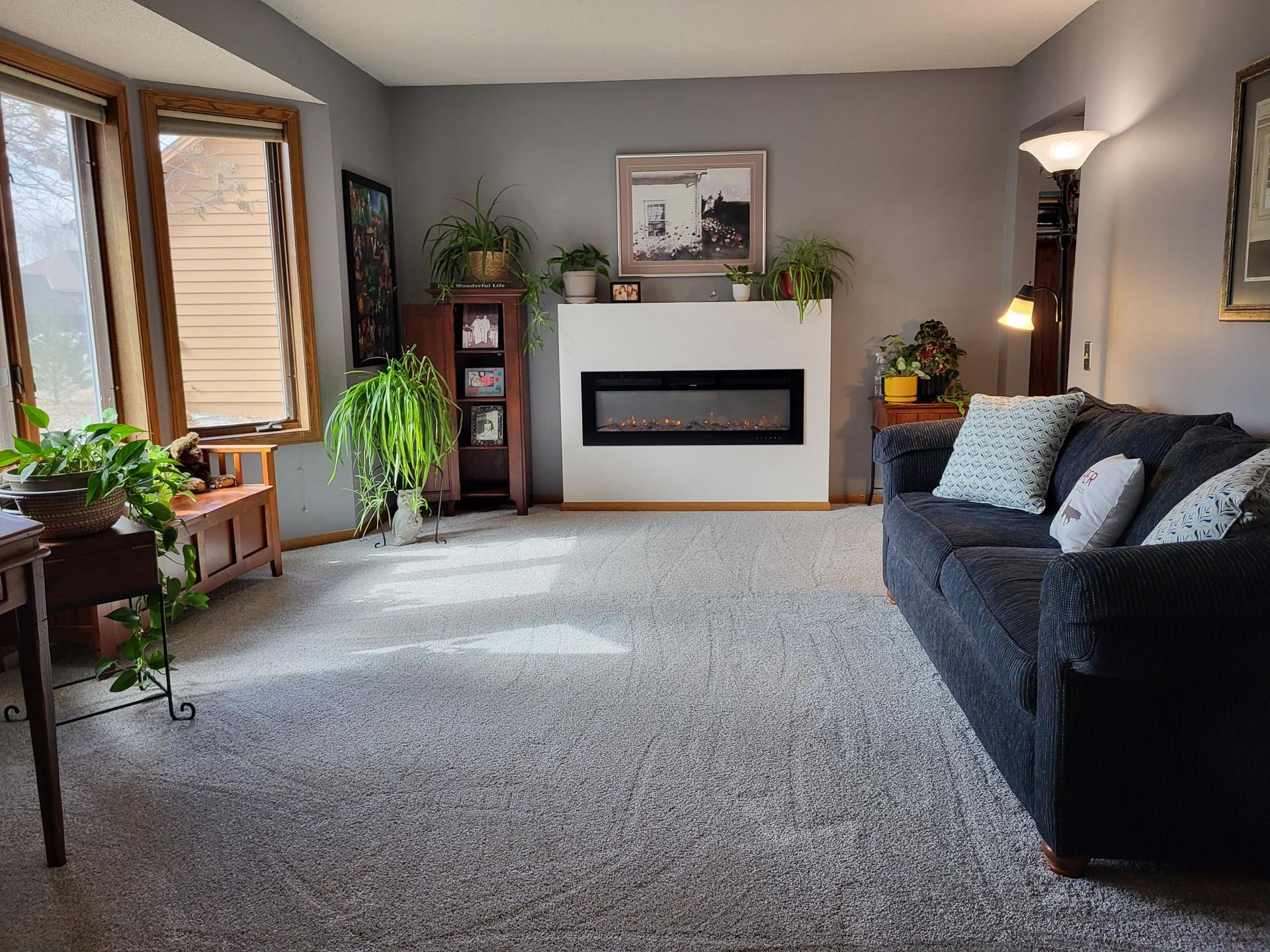 A close-up of a light gray wall with a rough, textured stucco or popcorn finish.
