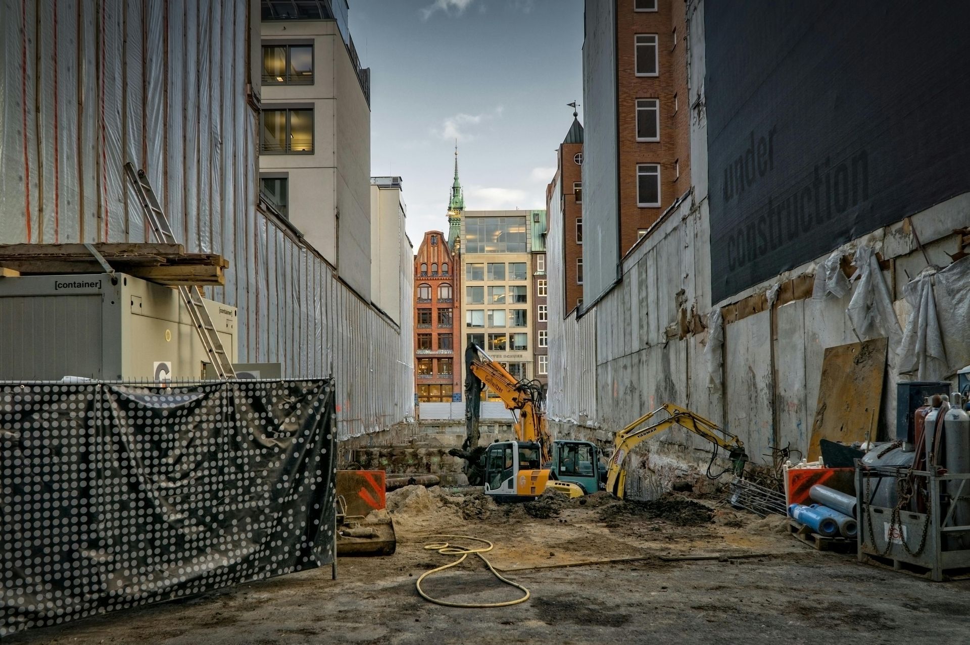 A construction site with a lot of machinery and buildings in the background.