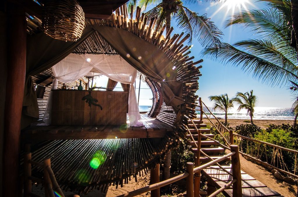 A tree house on the beach with stairs leading to it