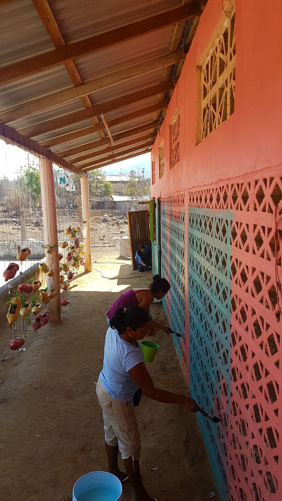 A woman is painting a wall with a brush.