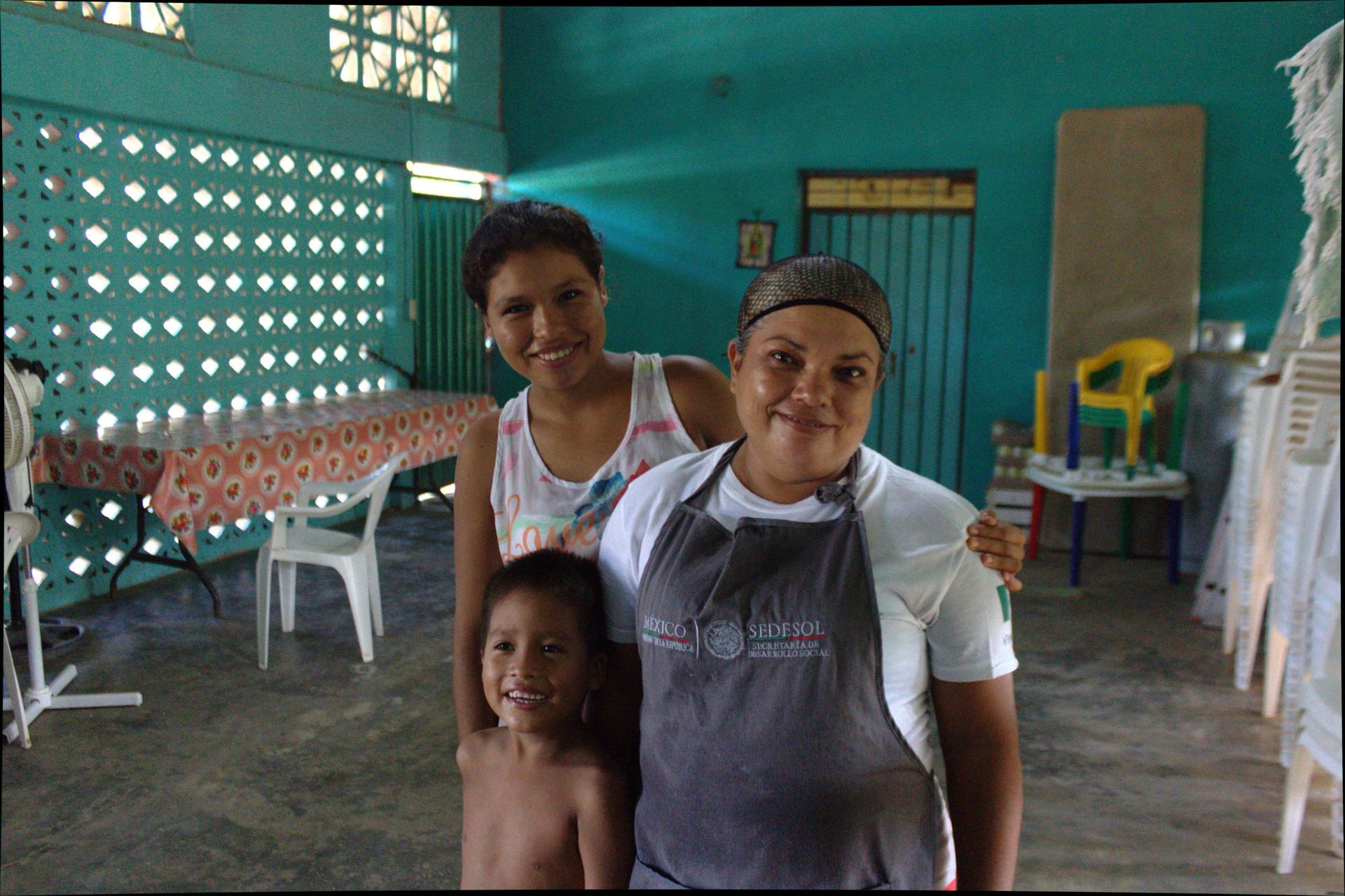 A woman wearing an apron stands next to a child