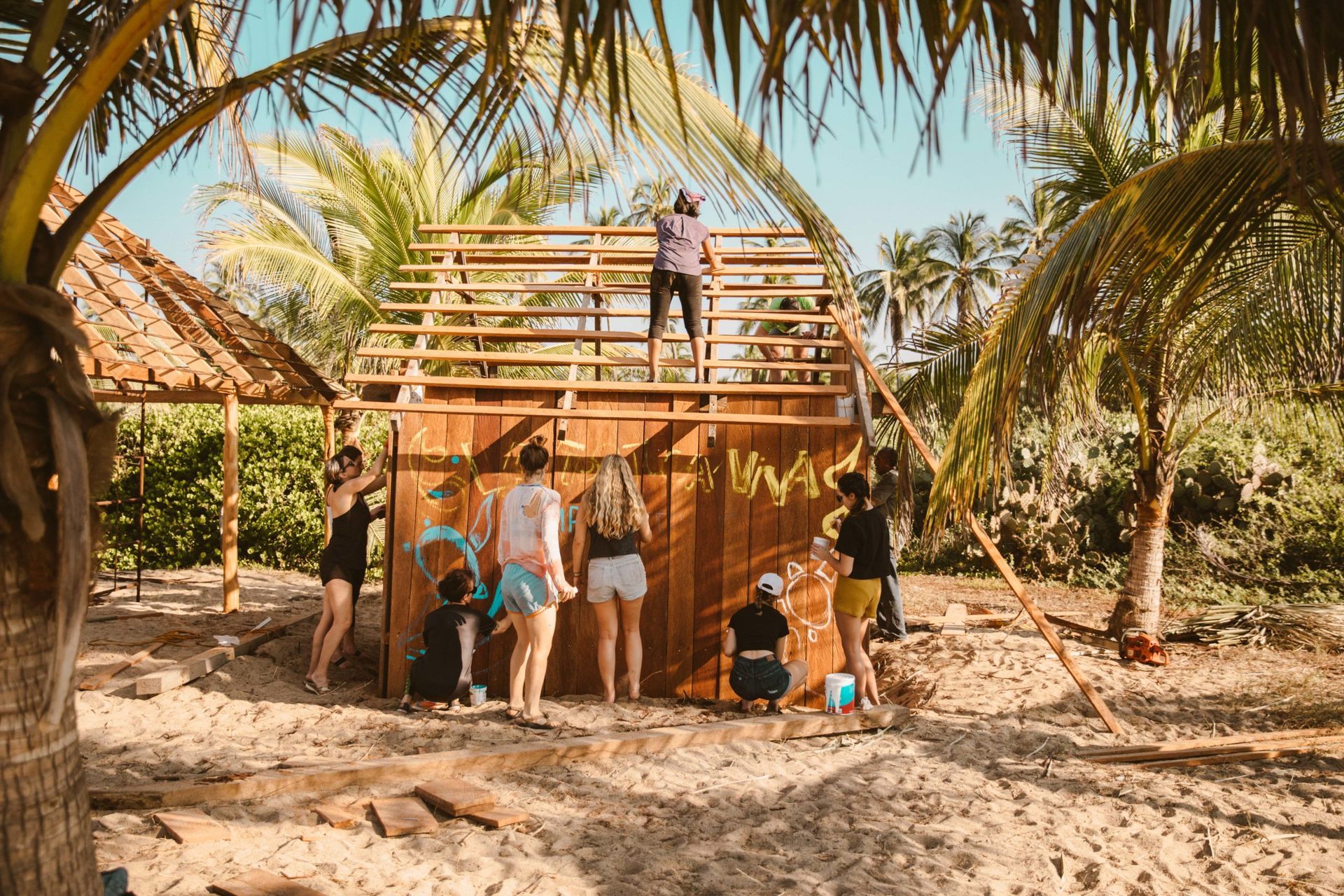A group of people are building a house on the beach.