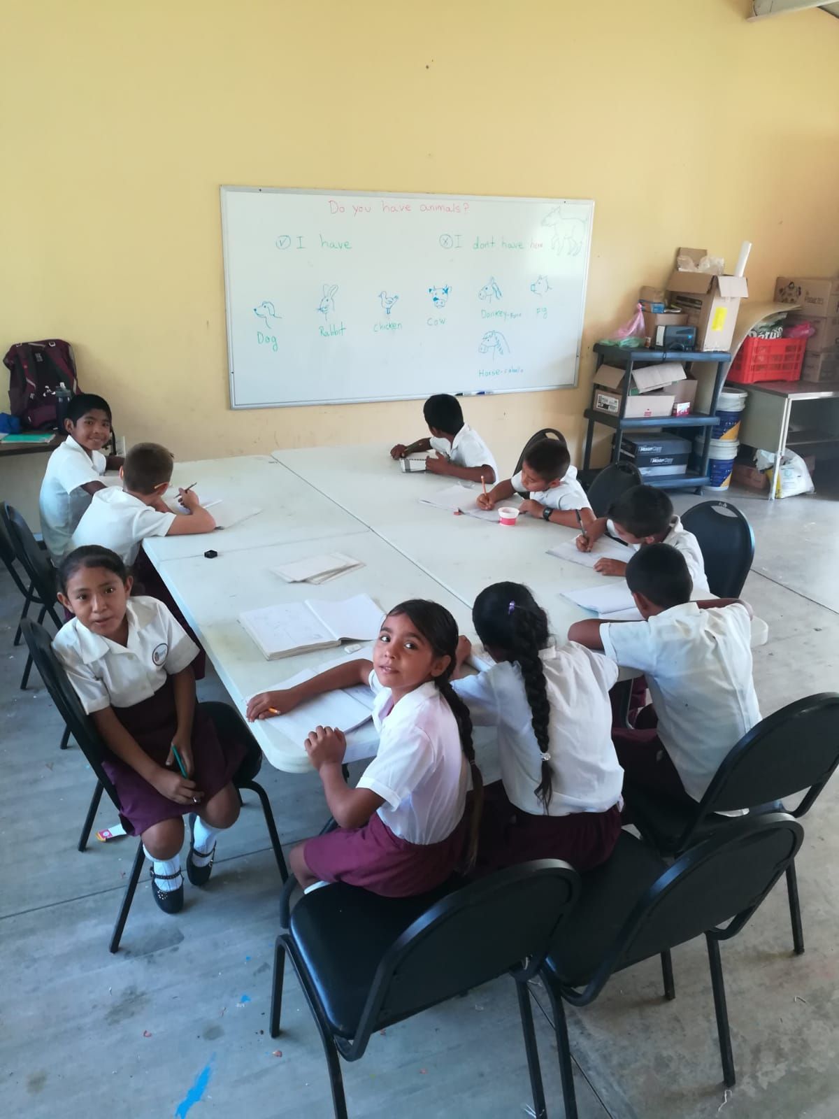 A group of children are sitting around a table in a classroom