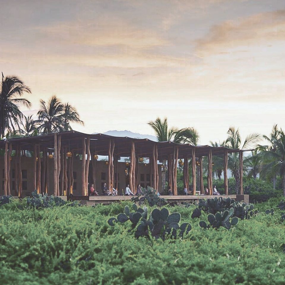 A wooden structure in the middle of a lush green field