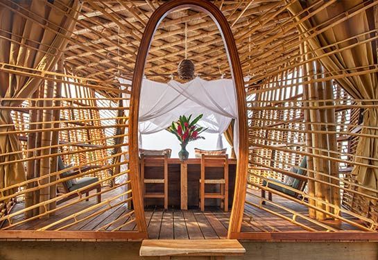 There is a table with a vase of flowers on it in the middle of the room.