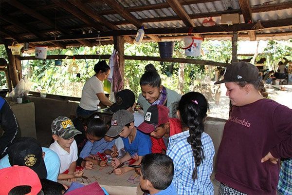 A group of people are gathered around a table and one of them is wearing a columbia shirt