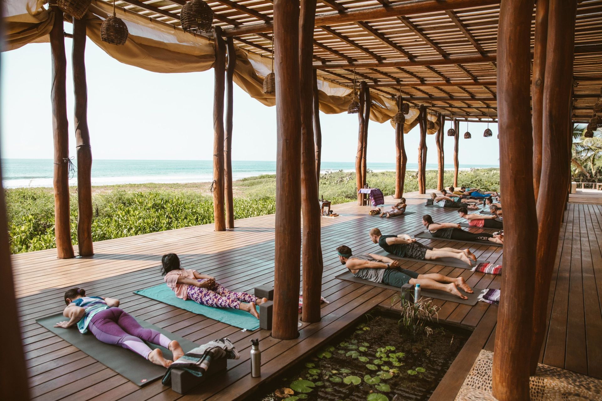 A group of people are doing yoga on a wooden deck.