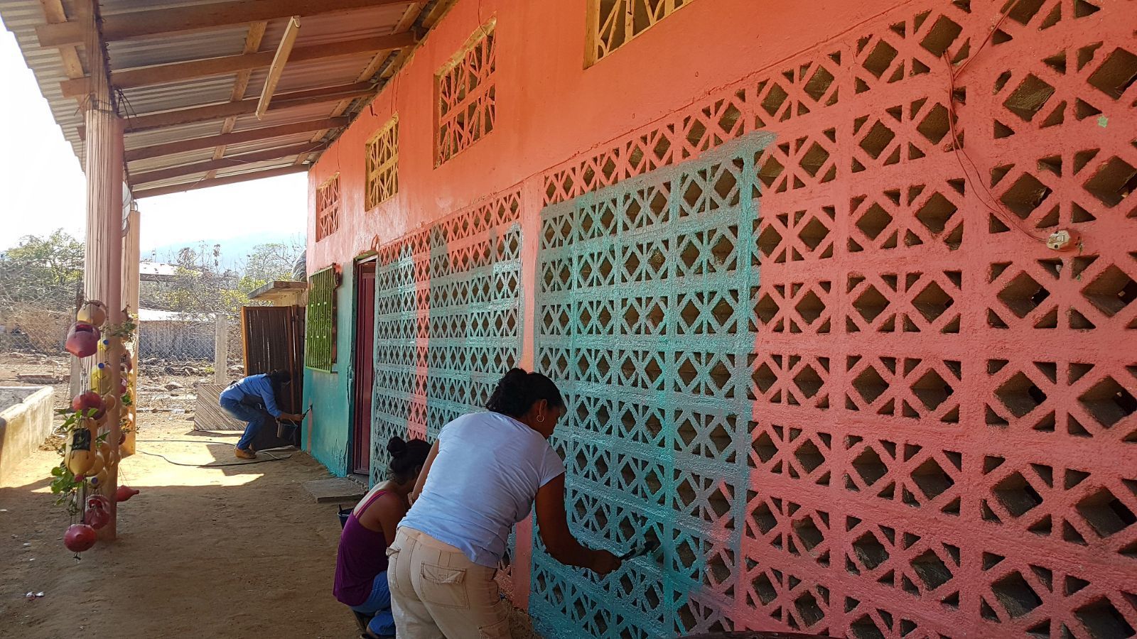 A group of people are painting a colorful wall.