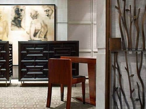 A room with a table and chairs and a painting on the wall.