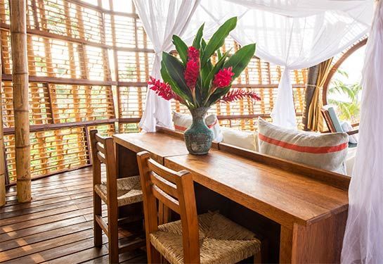 A wooden desk with a vase of flowers on it.