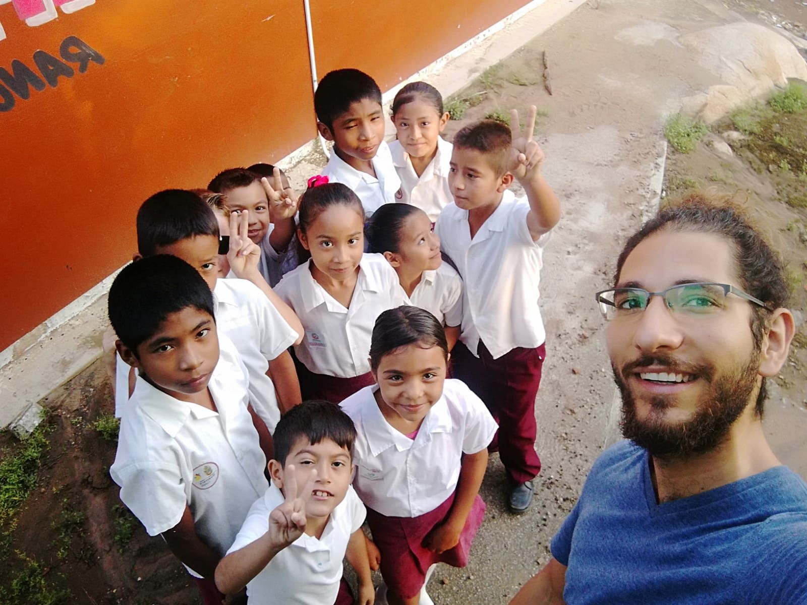 A man taking a selfie with a group of children