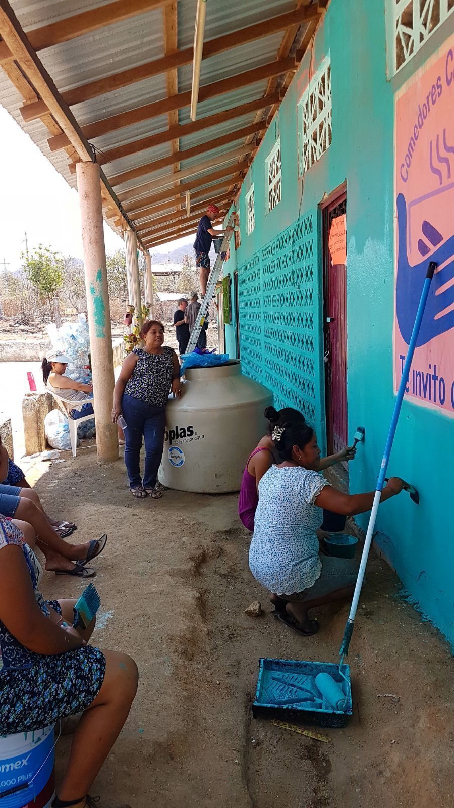 A group of people are painting a wall in a building.