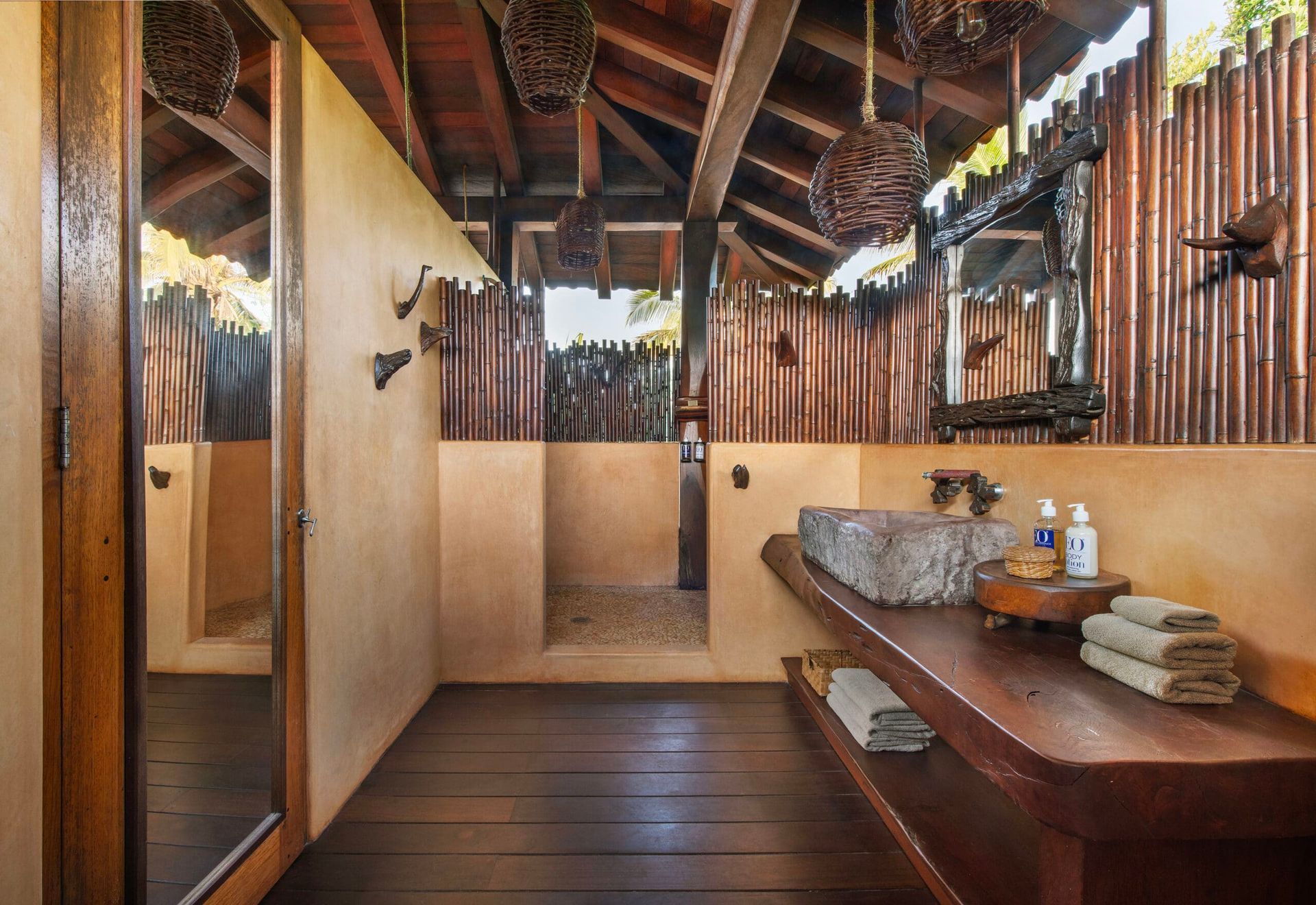 A bathroom with two sinks , a mirror and a walk in shower.