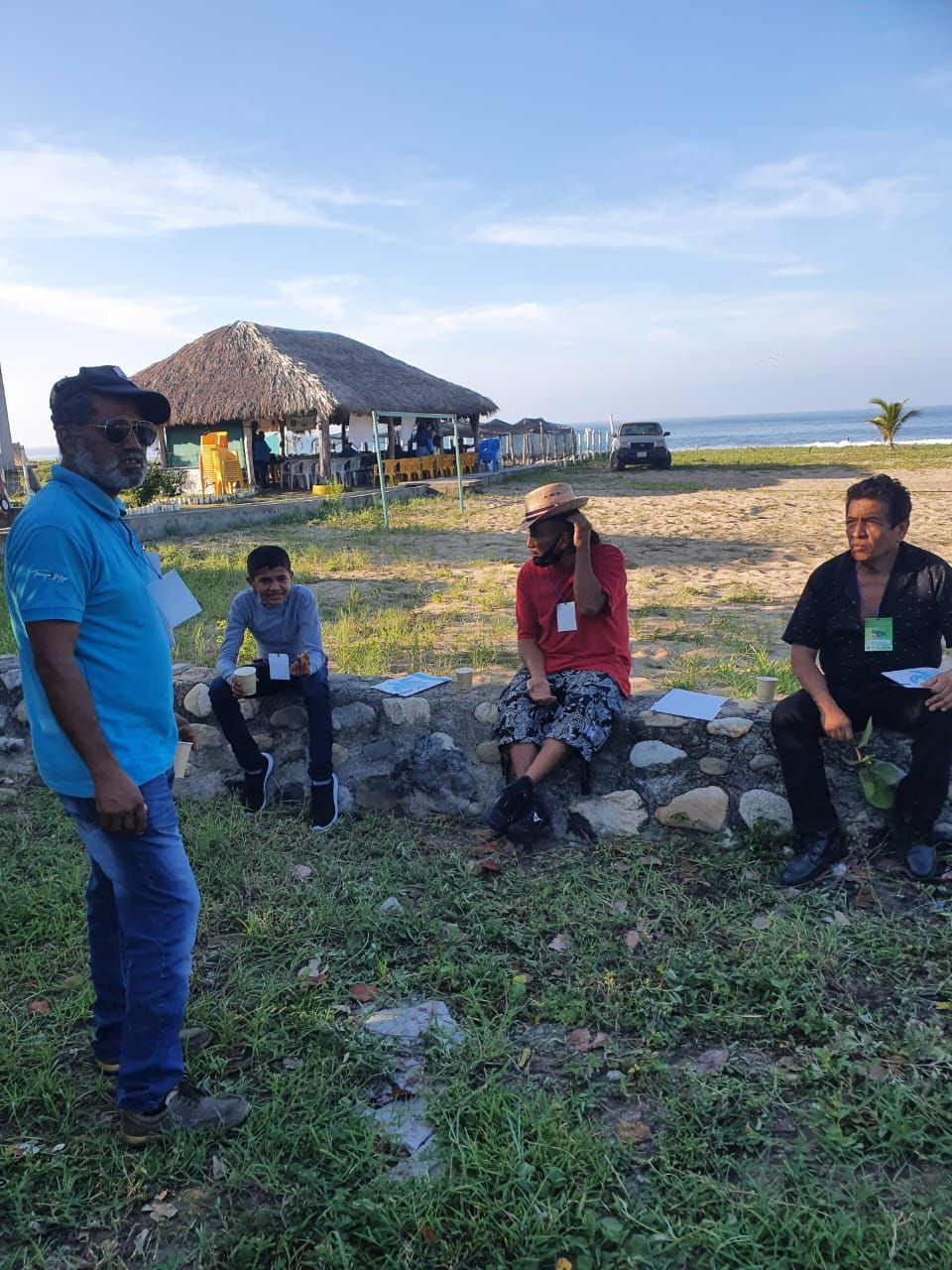 A group of people are sitting on rocks in a field.