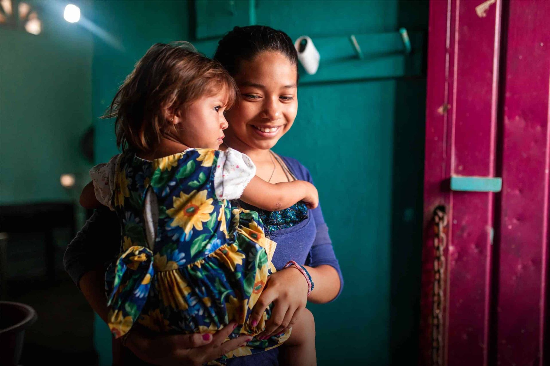A woman is holding a little girl in her arms.