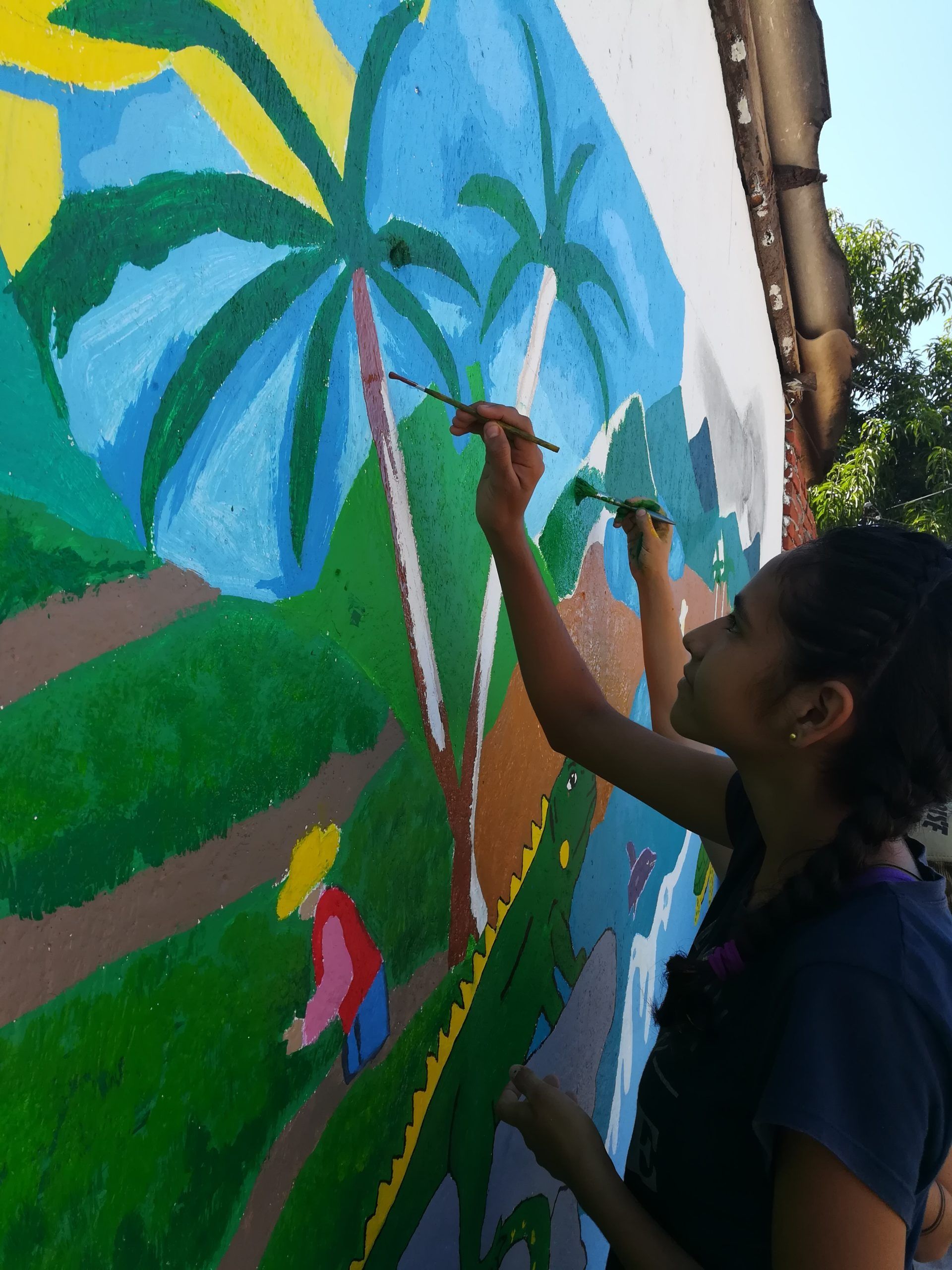 A woman is painting a picture on a wall with a brush
