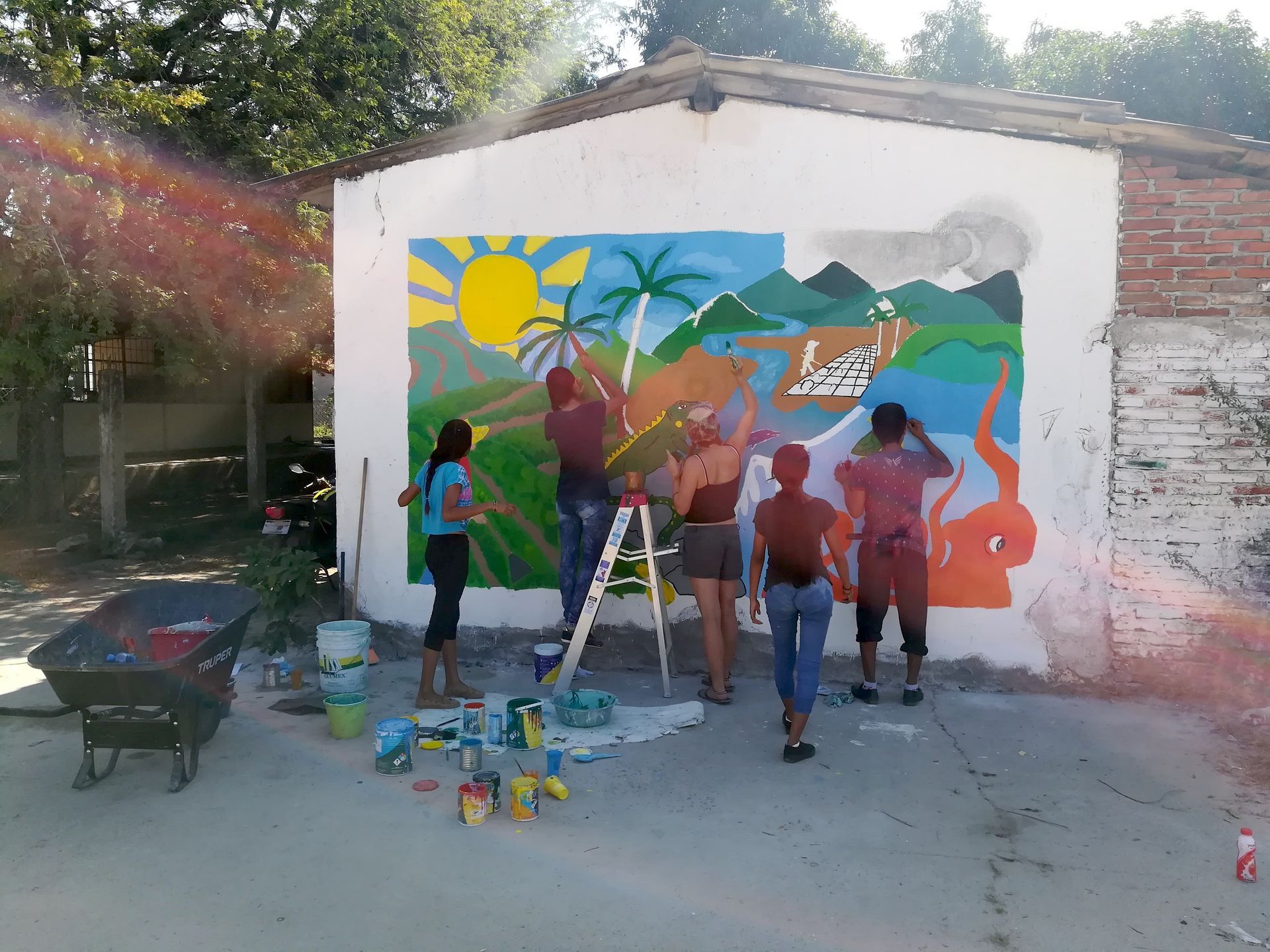 A group of people are painting a mural on the side of a building