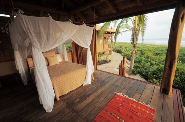 A bedroom with a canopy bed and a view of the ocean