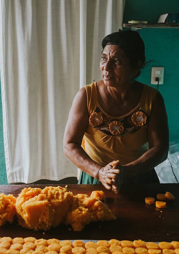 A woman is sitting at a table with a bunch of food on it.