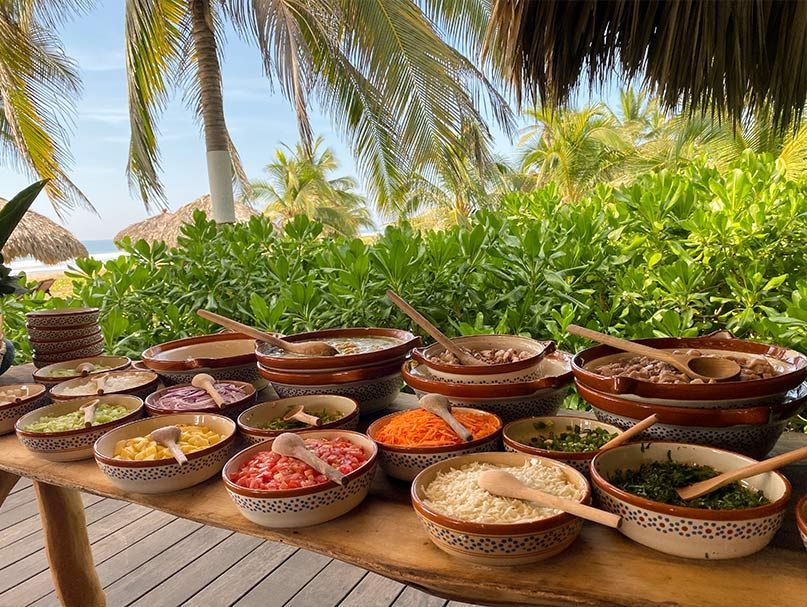 A table topped with bowls of food and spoons.