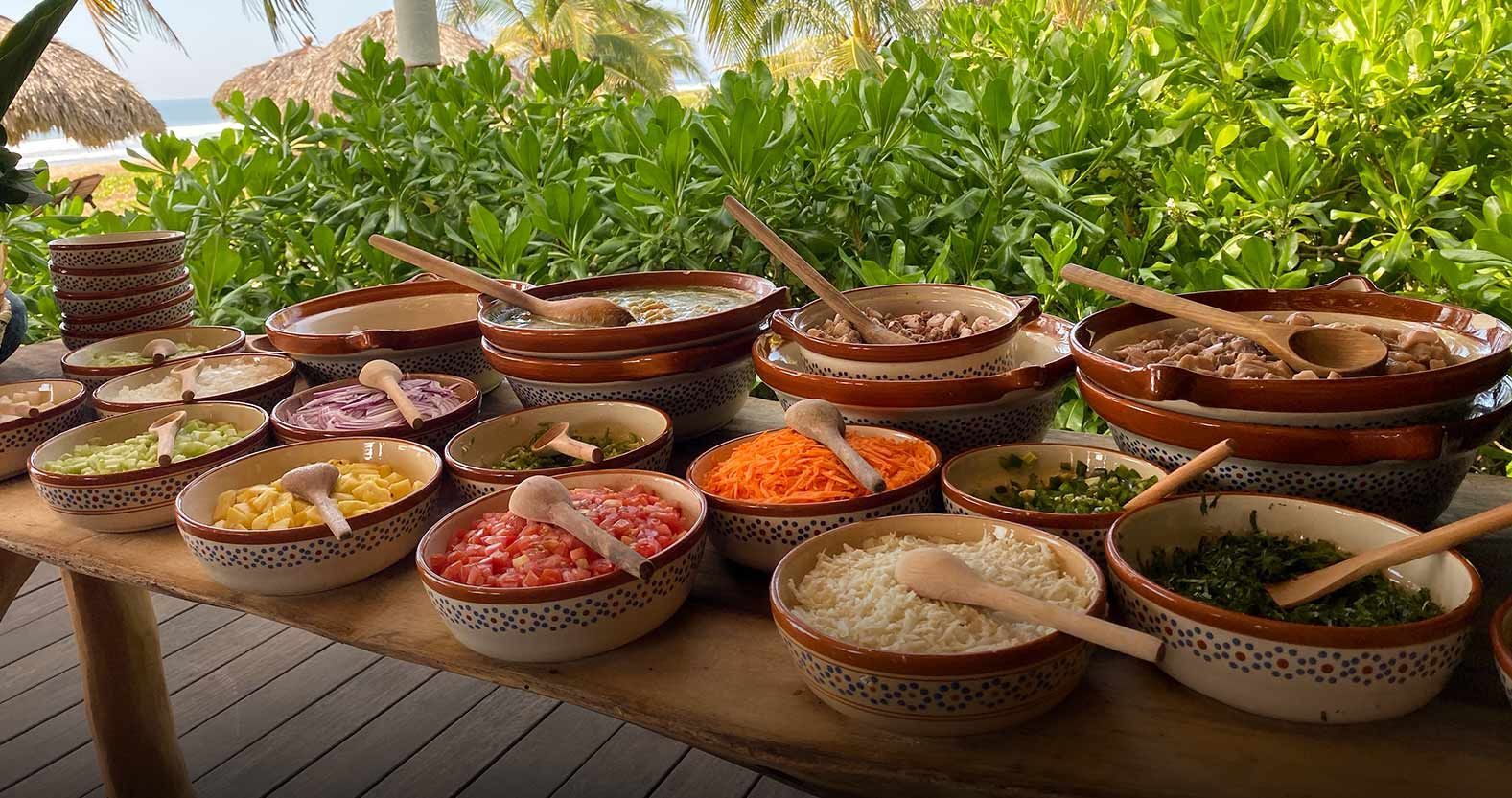 A table topped with bowls of food and spoons.