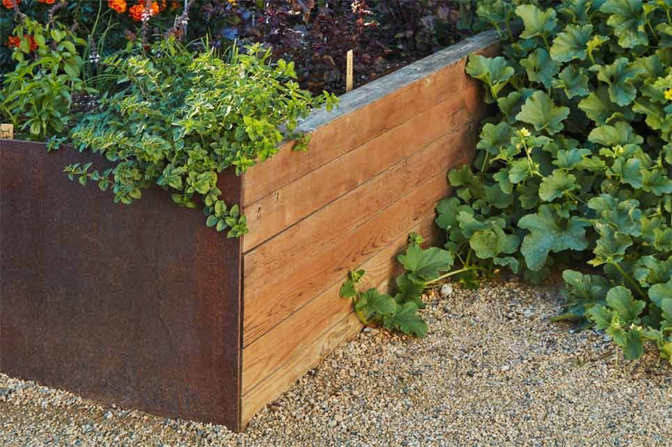 A wooden planter with plants growing out of it