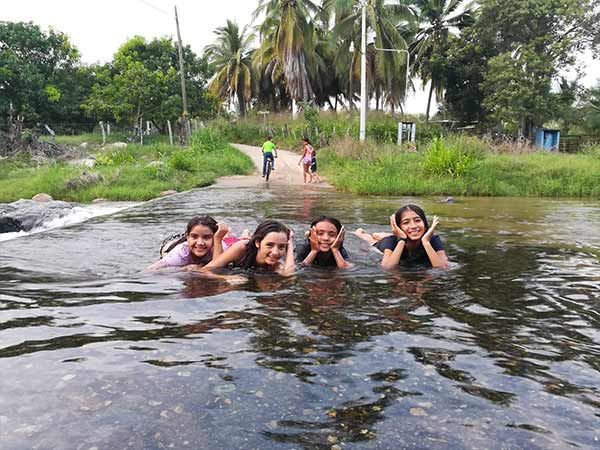 A group of girls are swimming in a river.