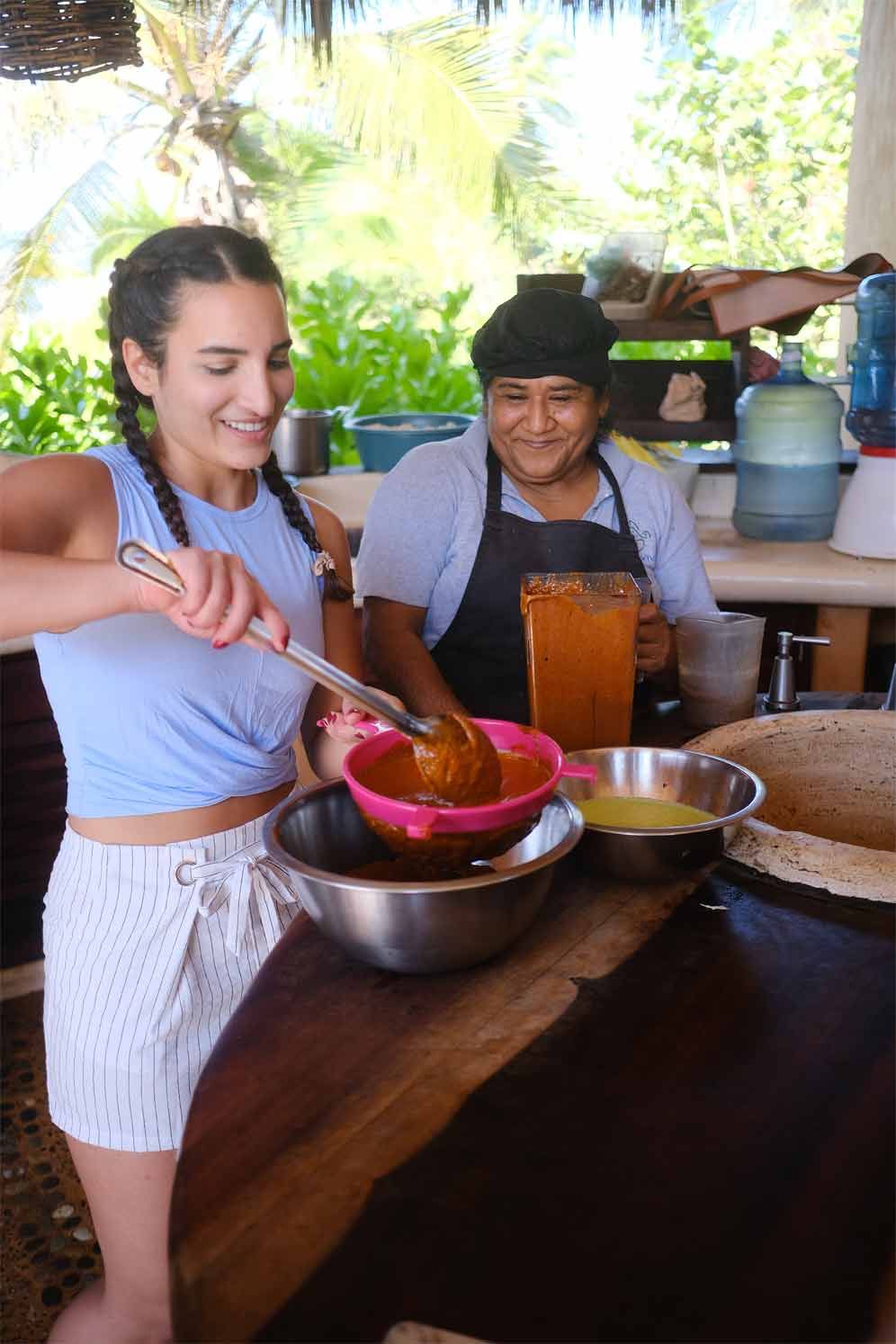 Two women are preparing food at a restaurant.