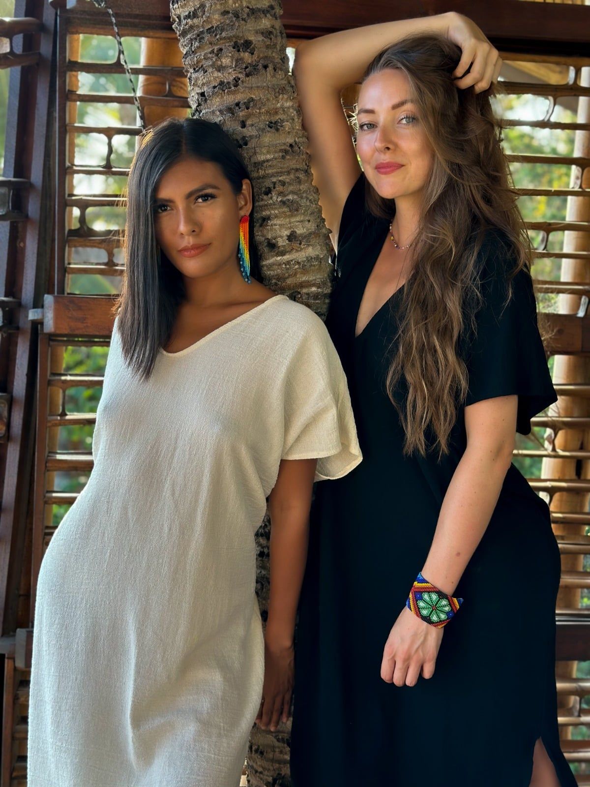 Two women standing next to each other one in a white dress and one in a black dress