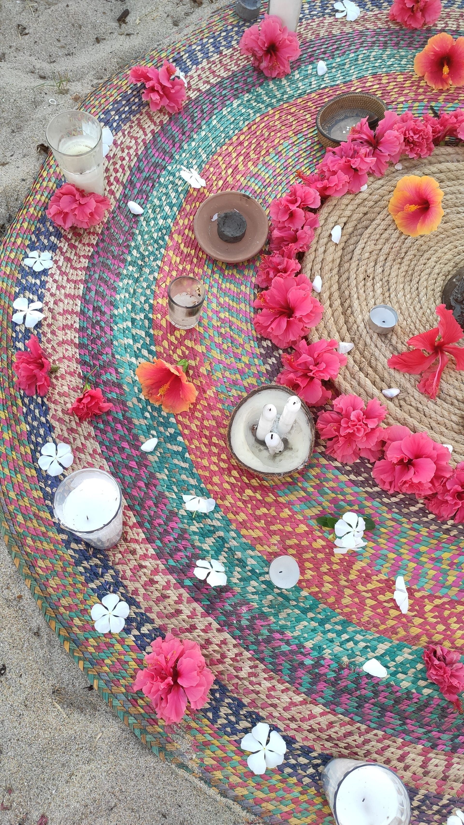 A colorful rug with pink flowers and seashells on it.