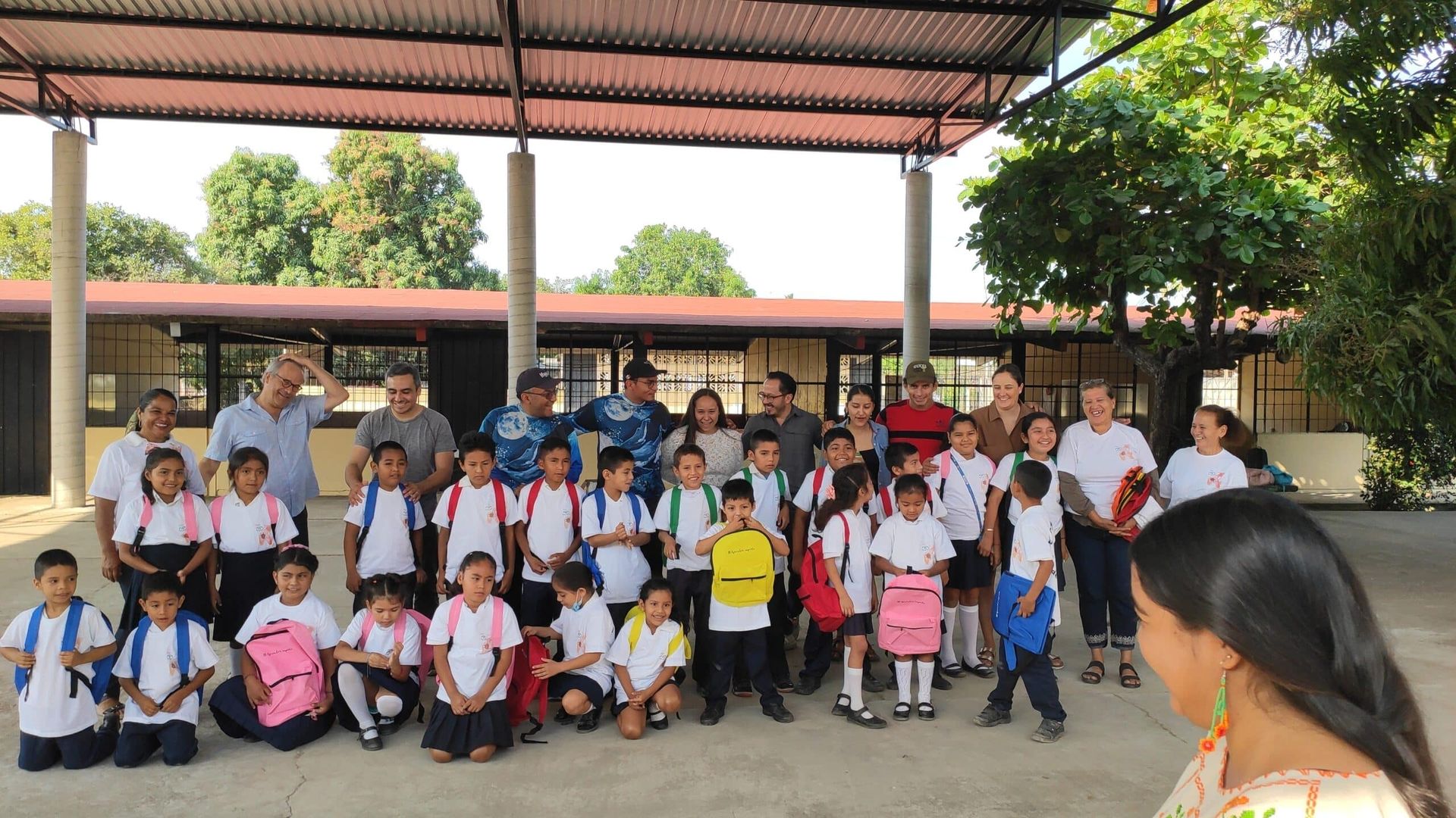 A group of children are posing for a picture in front of a school.