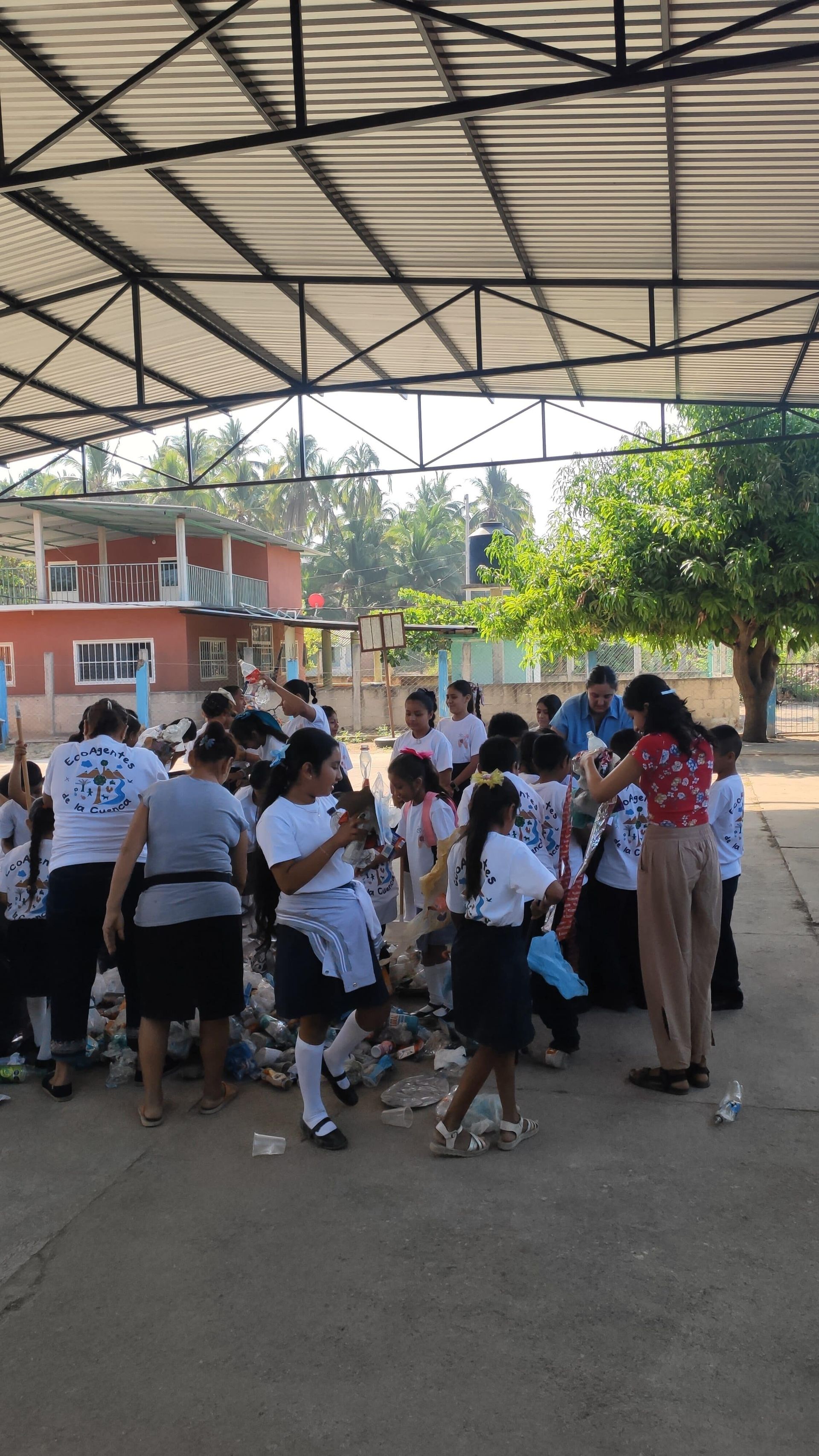 A group of people are standing in a room under a roof.