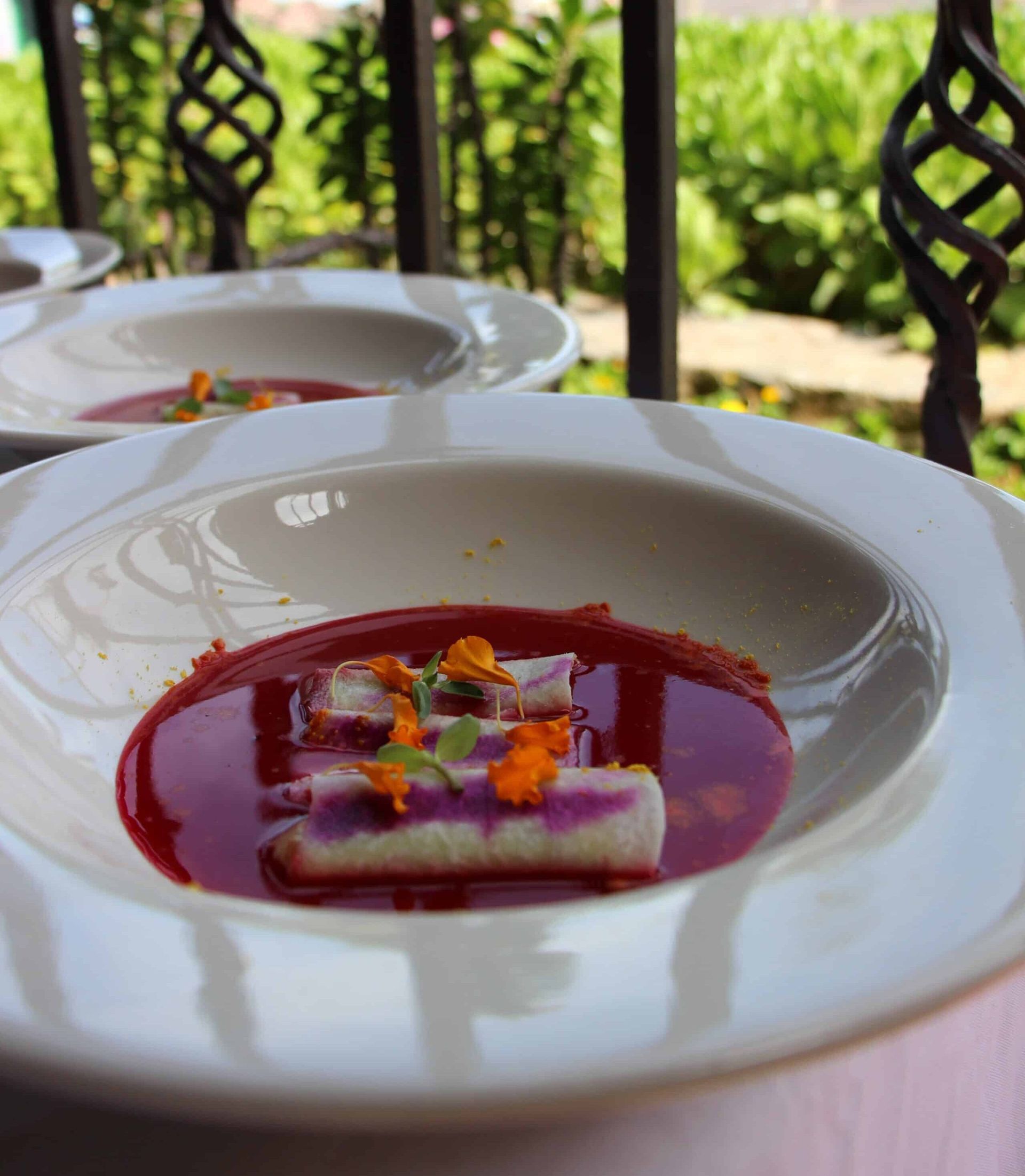 A close up of a bowl of soup with flowers on top