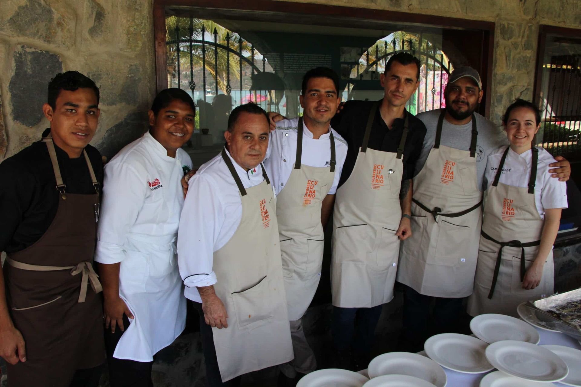 A group of chefs are posing for a picture in front of plates