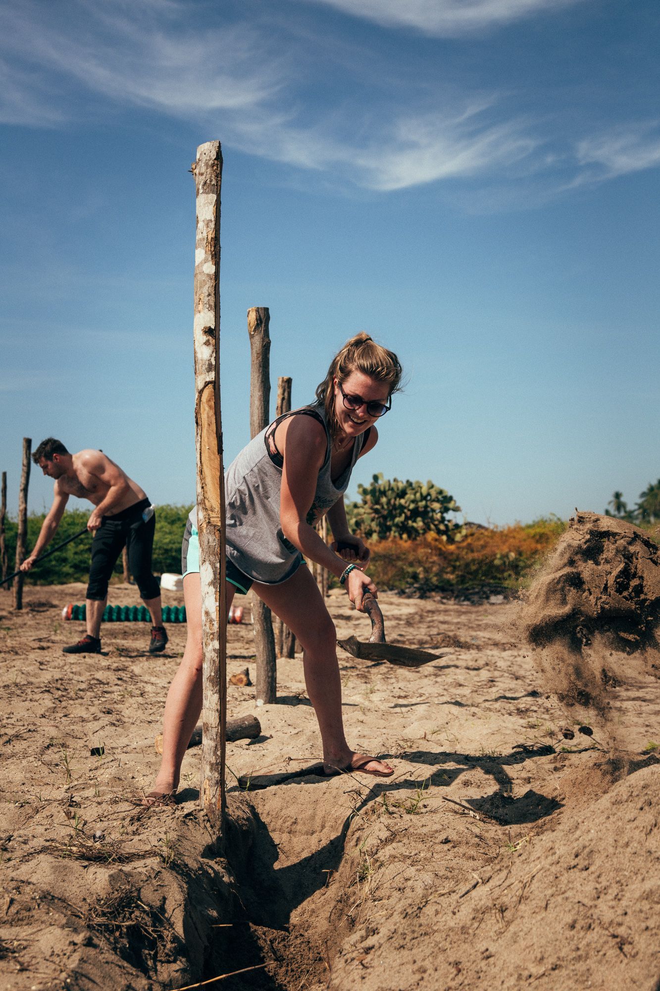 A man and a woman are digging in the dirt.