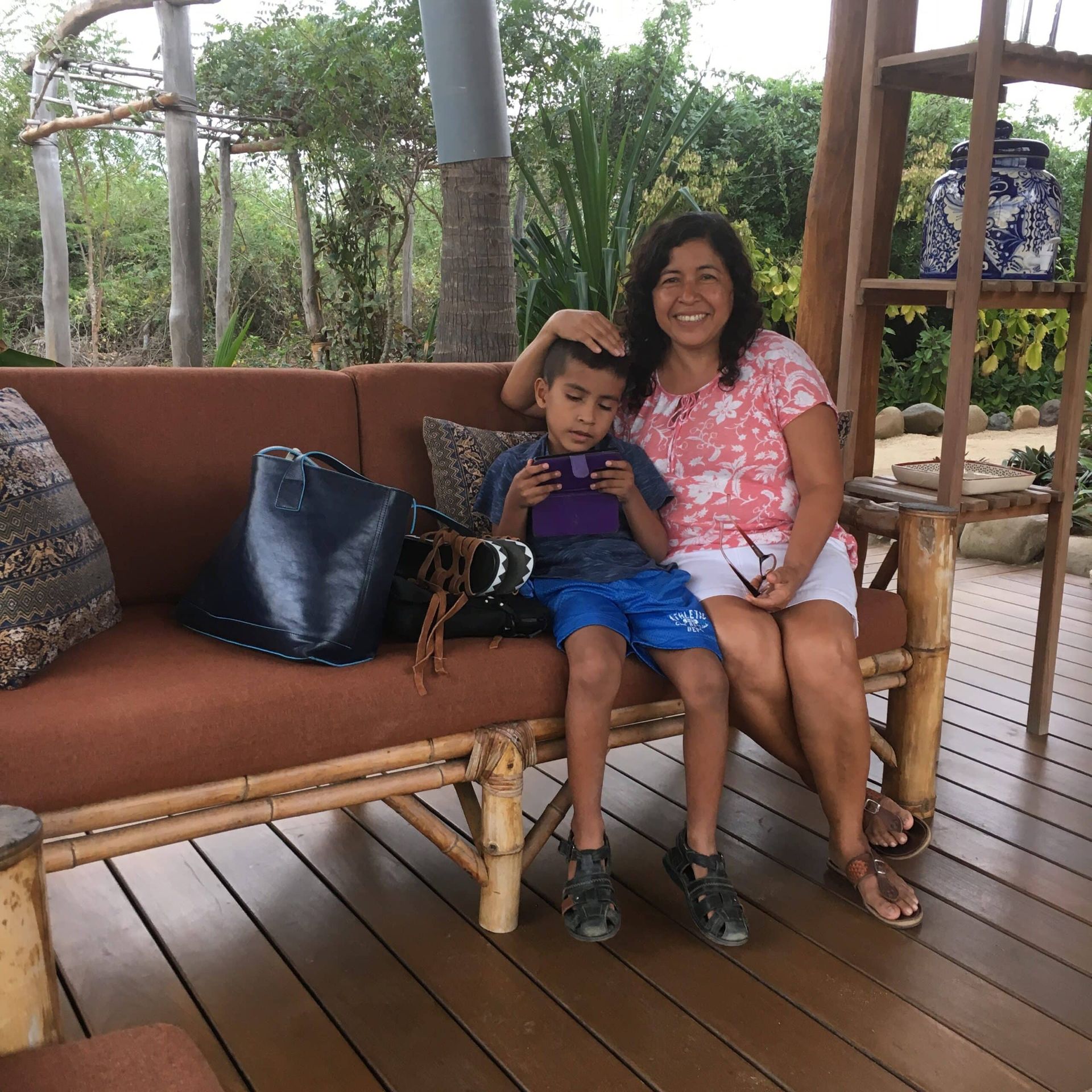 A woman and child are sitting on a wooden couch