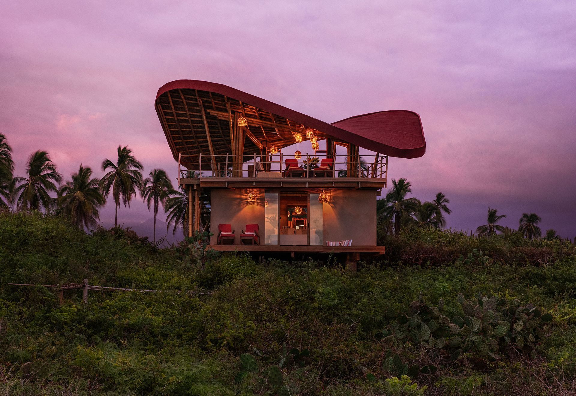 A house is sitting on top of a hill in the middle of a forest.