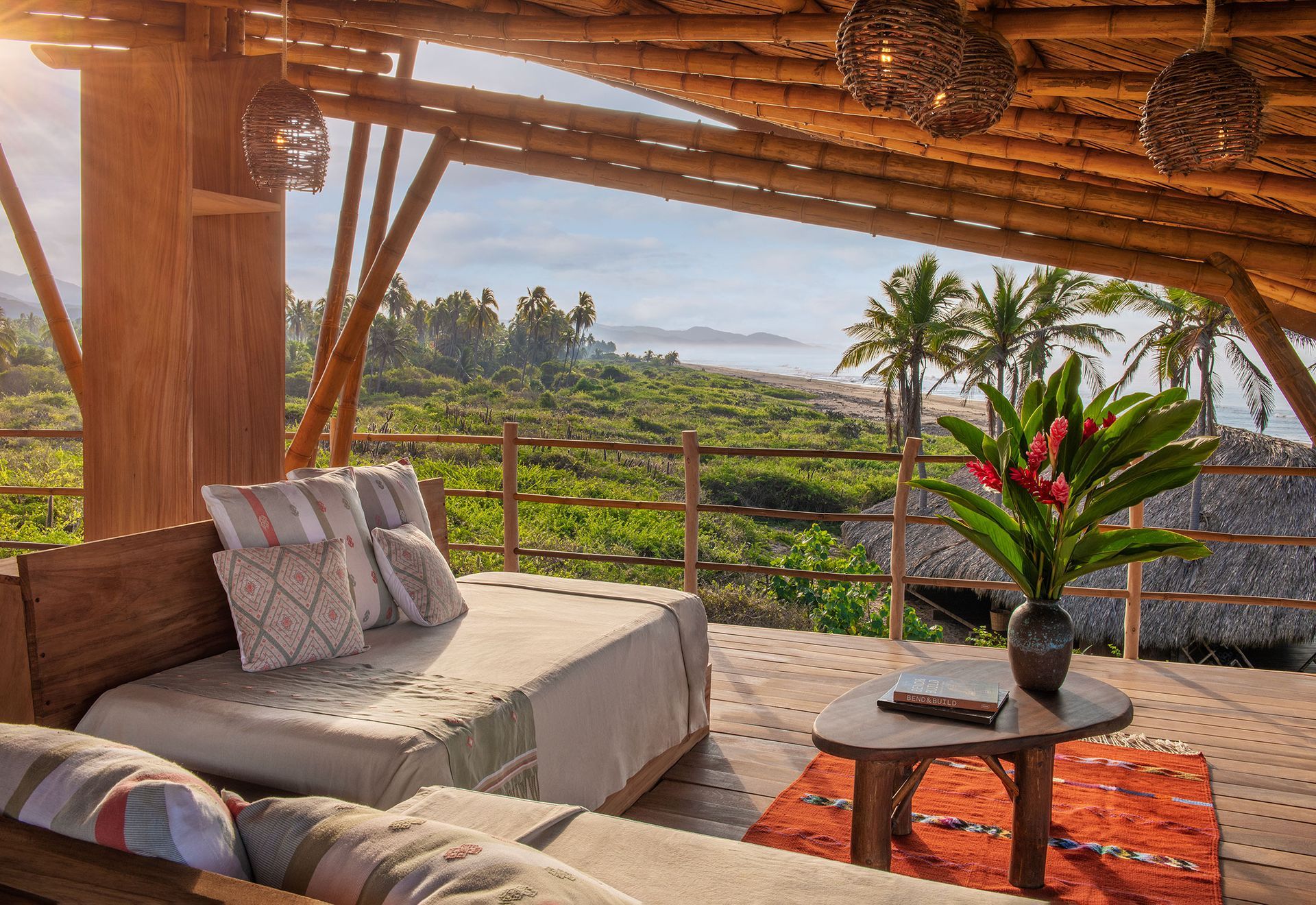 A living room with a bed and a table with a view of the ocean.
